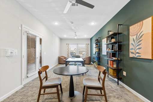 A room with a round table and chairs.