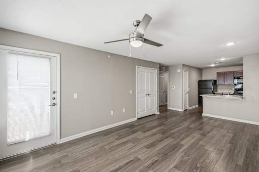A room with a ceiling fan and wooden flooring.