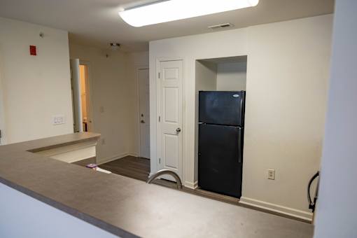 A kitchen with a black fridge and a white door.