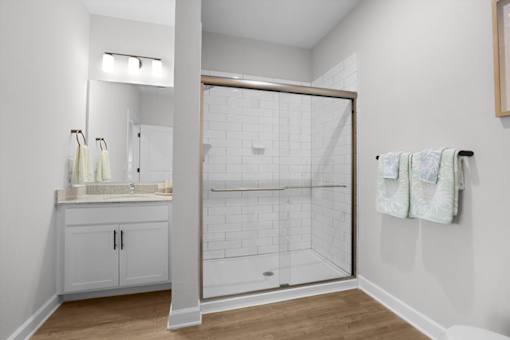 A white bathroom with a walk in shower.