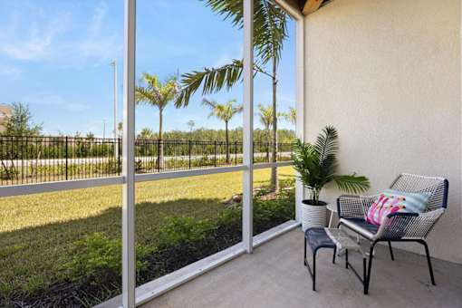 A patio with a chair and a potted plant.