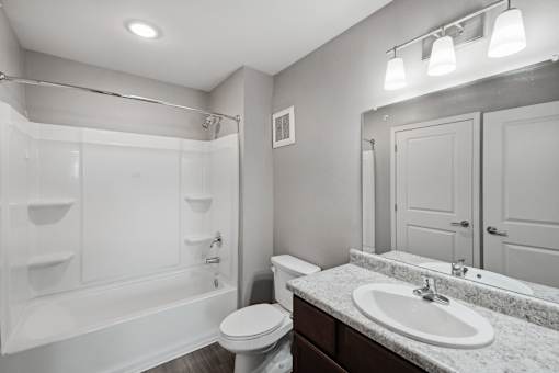 A white bathroom with a toilet, sink, and bathtub.