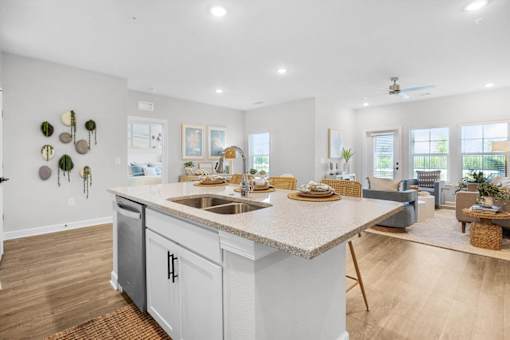 A kitchen with a large island and a dining area in the background.