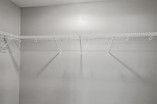 A white closet with a metal rack.