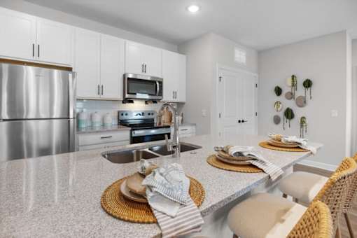 A modern kitchen with a stainless steel refrigerator, a microwave, and a stove top oven.