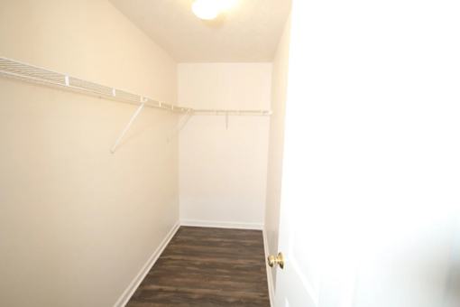 A room with a white wall and a wooden floor.