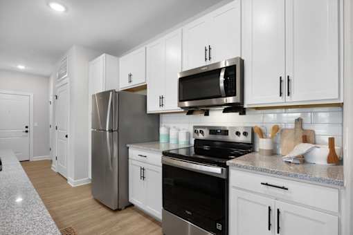 A kitchen with white cabinets and stainless steel appliances.