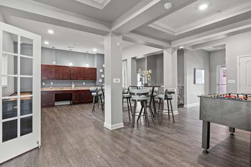 A room with a dining table and chairs.
