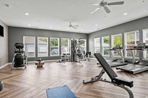 A spacious gym with a variety of equipment and a blue mat on the floor.