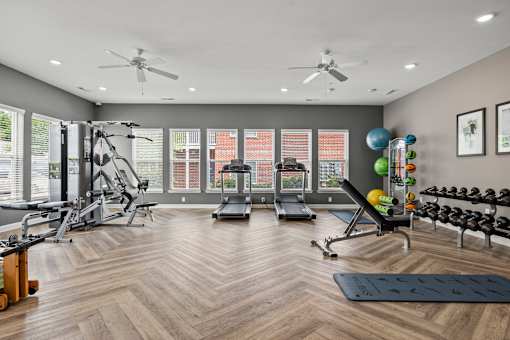 A spacious gym with a variety of equipment and a large mirror on the wall.