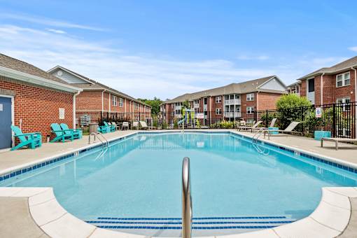 A swimming pool in front of apartment buildings.