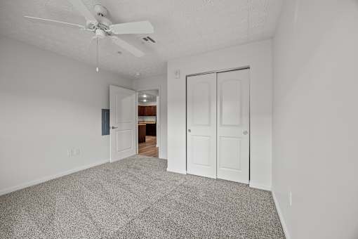 A room with a ceiling fan and a carpeted floor.