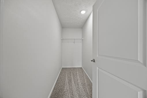 A hallway with a striped carpet and white walls.