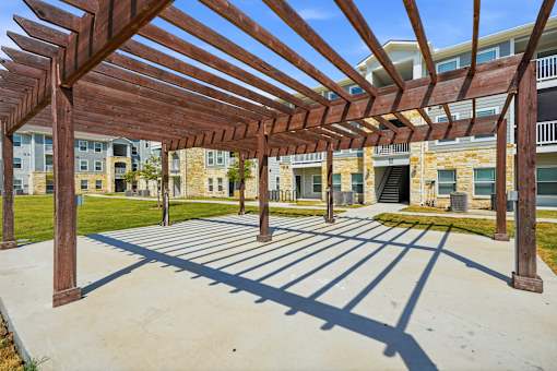 A wooden pergola provides shade over a walkway.