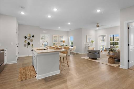 A spacious kitchen with a dining area and a living room with a couch and a coffee table.