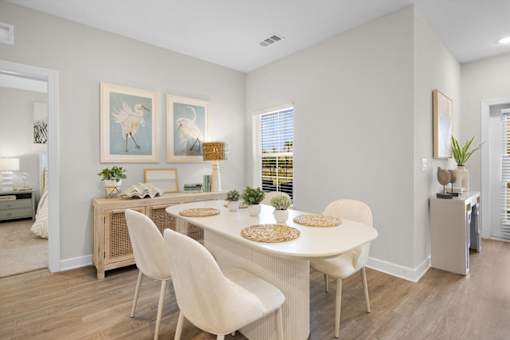 A dining room with a white table and chairs.