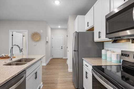 A modern kitchen with a stainless steel refrigerator and oven.