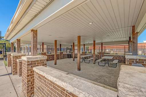 A covered outdoor seating area with tables and chairs.