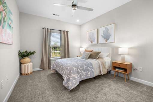 A bedroom with a bed, nightstand, and a ceiling fan.