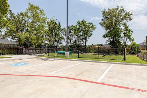 A parking lot with a blue handicap sign painted on the pavement.
