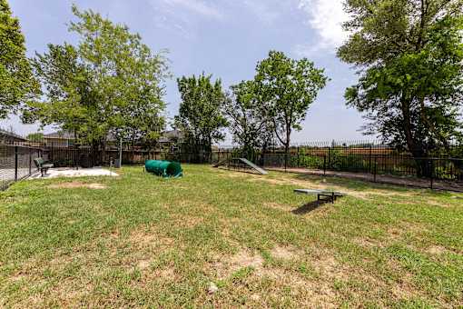 A green tarp is in the middle of a grassy field.