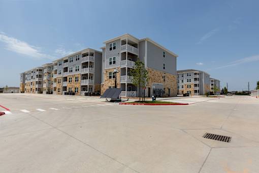 A large building complex with a parking lot in front.
