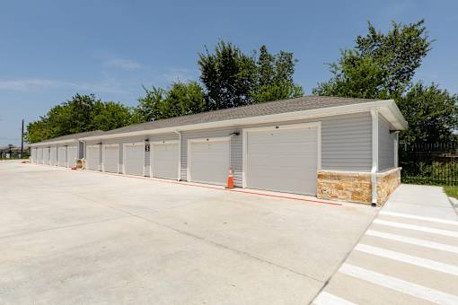 A long building with a grey roof and grey garage doors.