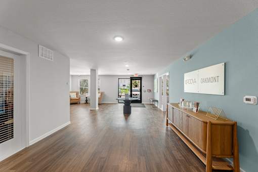 A hallway with a wooden floor and a white wall with a sign that says "Oakmont".