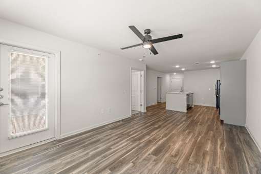 A room with a ceiling fan and wooden flooring.