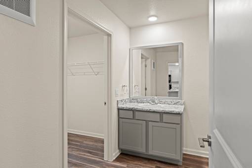 A bathroom with a marble countertop and a large mirror.