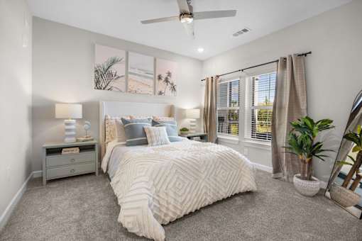 A bedroom with a large bed and a ceiling fan.