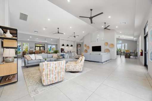 A spacious living room with a grey sofa set and a patterned armchair.