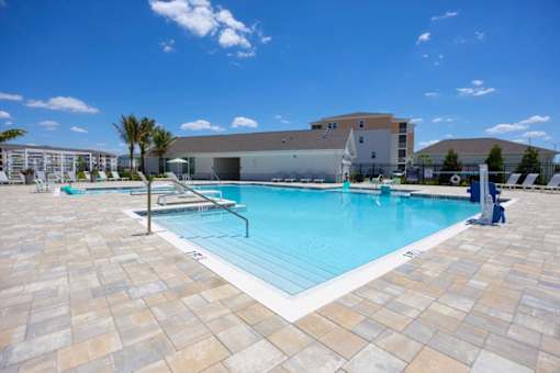 A large swimming pool surrounded by a tiled patio.