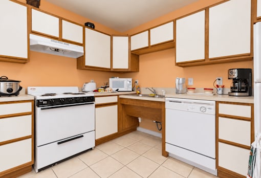 A kitchen with white appliances and wooden cabinets.