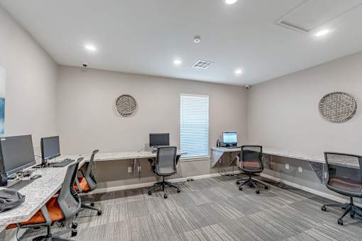 A well-lit office space with a desk, chairs, and computers.