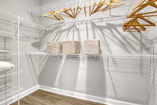 A room with a white wall and a shelf with baskets on it.