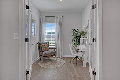 A room with a chair and a plant.