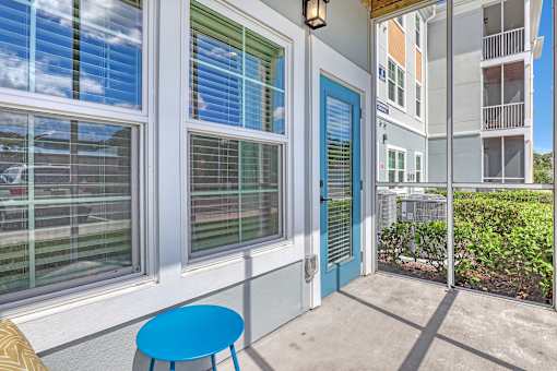 A blue chair sits on a patio in front of a white building.