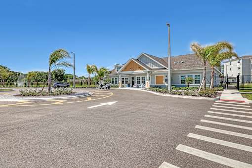 A large, open parking lot in front of a building with a clear blue sky above.