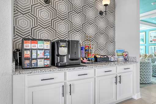 A kitchen with a patterned wallpaper and a coffee machine.