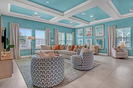 A living room with a large sofa, a round ottoman, and a coffee table.