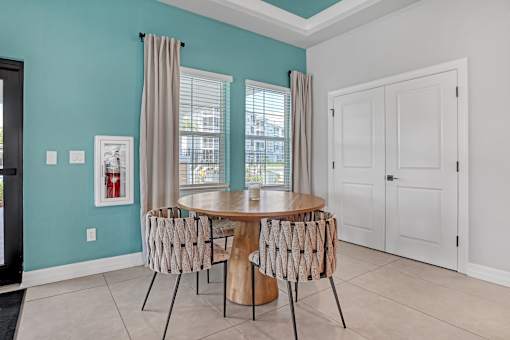 A dining room with a table and chairs.
