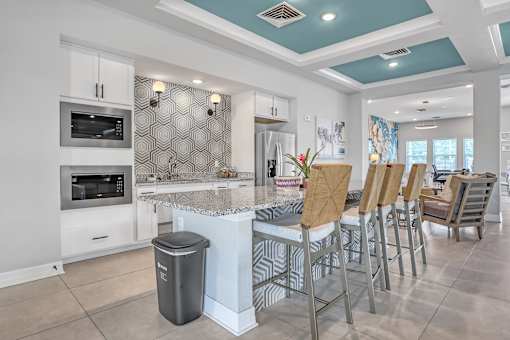 A modern kitchen with a large island and bar stools.