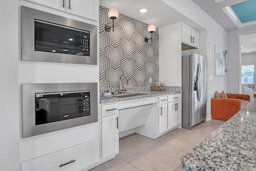 A modern kitchen with a granite countertop and stainless steel appliances.