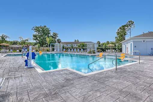 A large outdoor swimming pool surrounded by a stone patio.