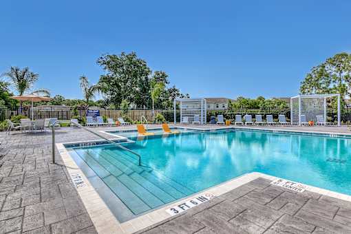 A large swimming pool with a blue tinted water and a white line on the edge.