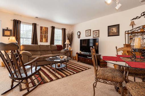 A living room with a brown couch, a chair, a coffee table, and a fireplace.