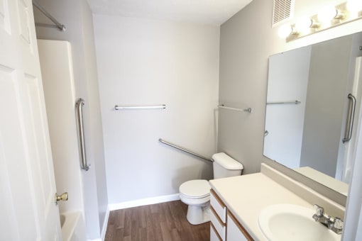 Bathroom with a toilet sink and mirror at Conner Court apartments in Connersville, IN