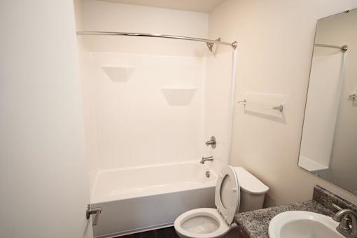 A white bathroom with a toilet, sink, and bathtub.