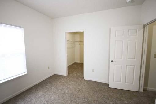 A room with a carpeted floor and a white door.